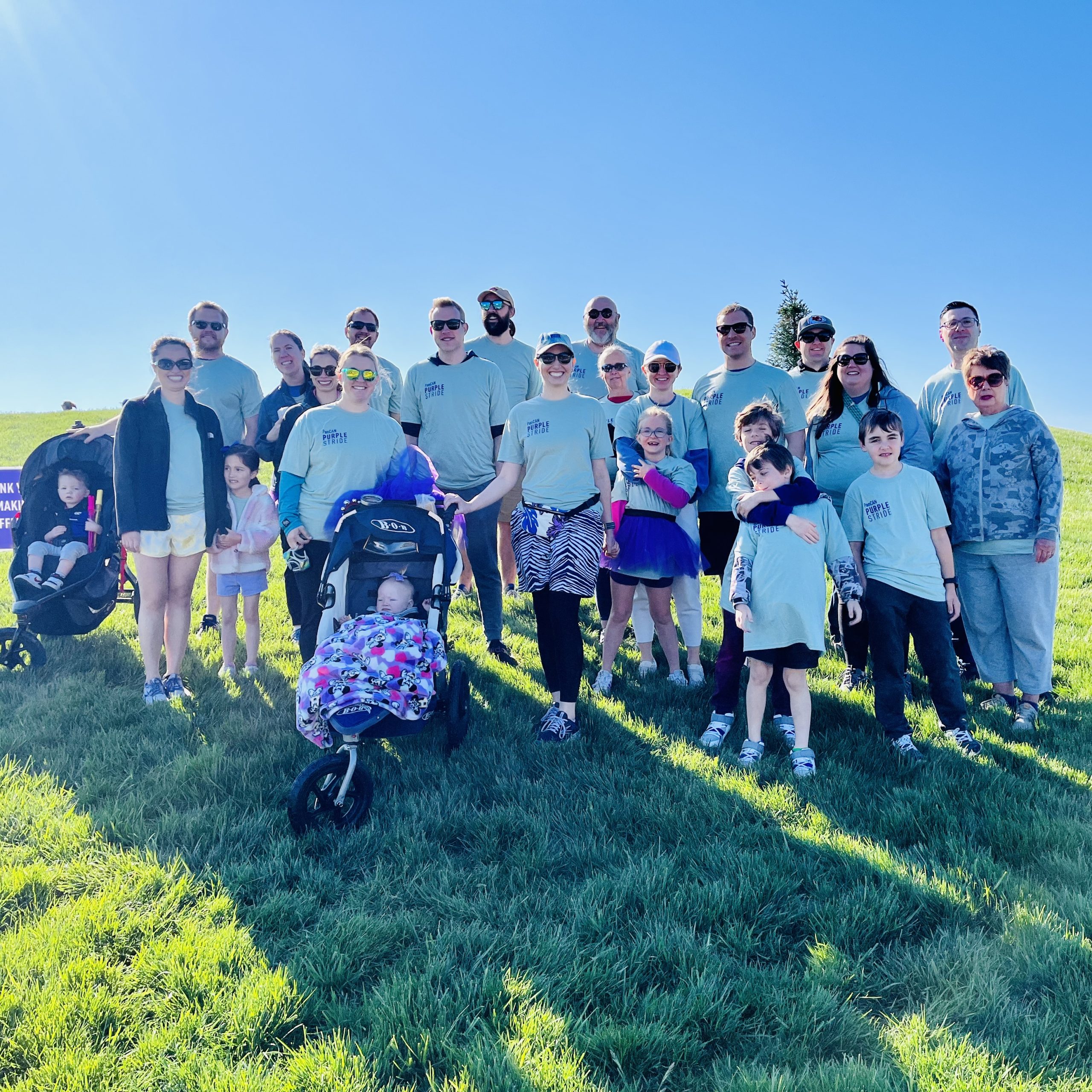 Group of people posing for a picture outside at the PanCAN Purple Stride